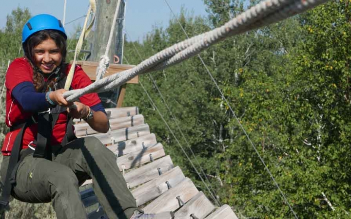 a student holds a rope while complete a ropes course with outward bound